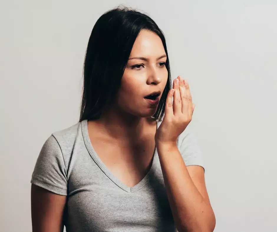 A woman checking her breath for bad smells